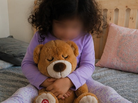 Petite fille câlinant son ourson Lylou